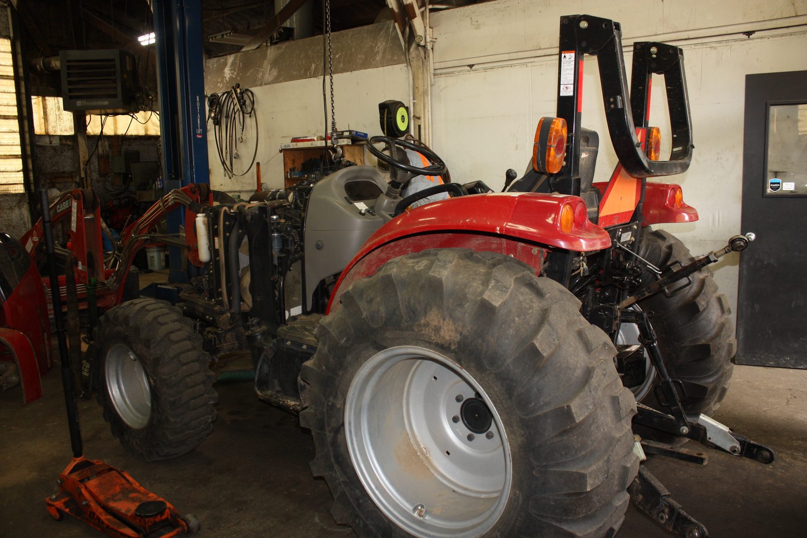 Diesel tractor up on a lift for repair at Cascade Farm and Fleet Services in Silverton, Oregon